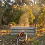 Wood fired hot tub at sunset with the coil burning beside it